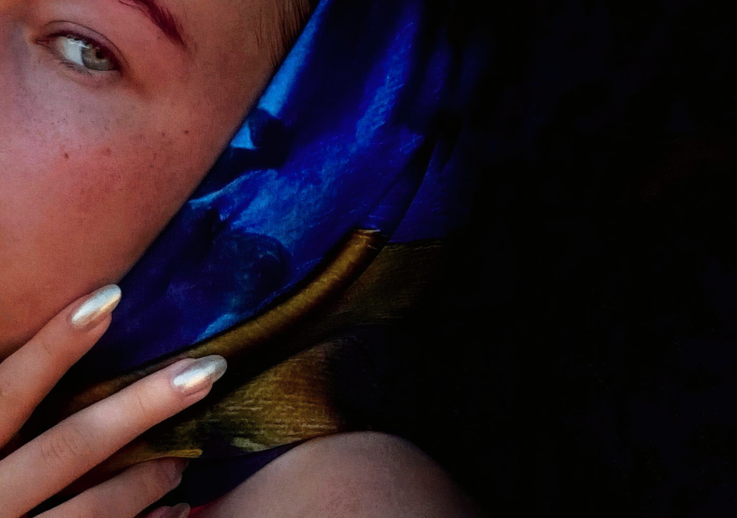 Close-up of a person wearing a blue scarf with a dark background